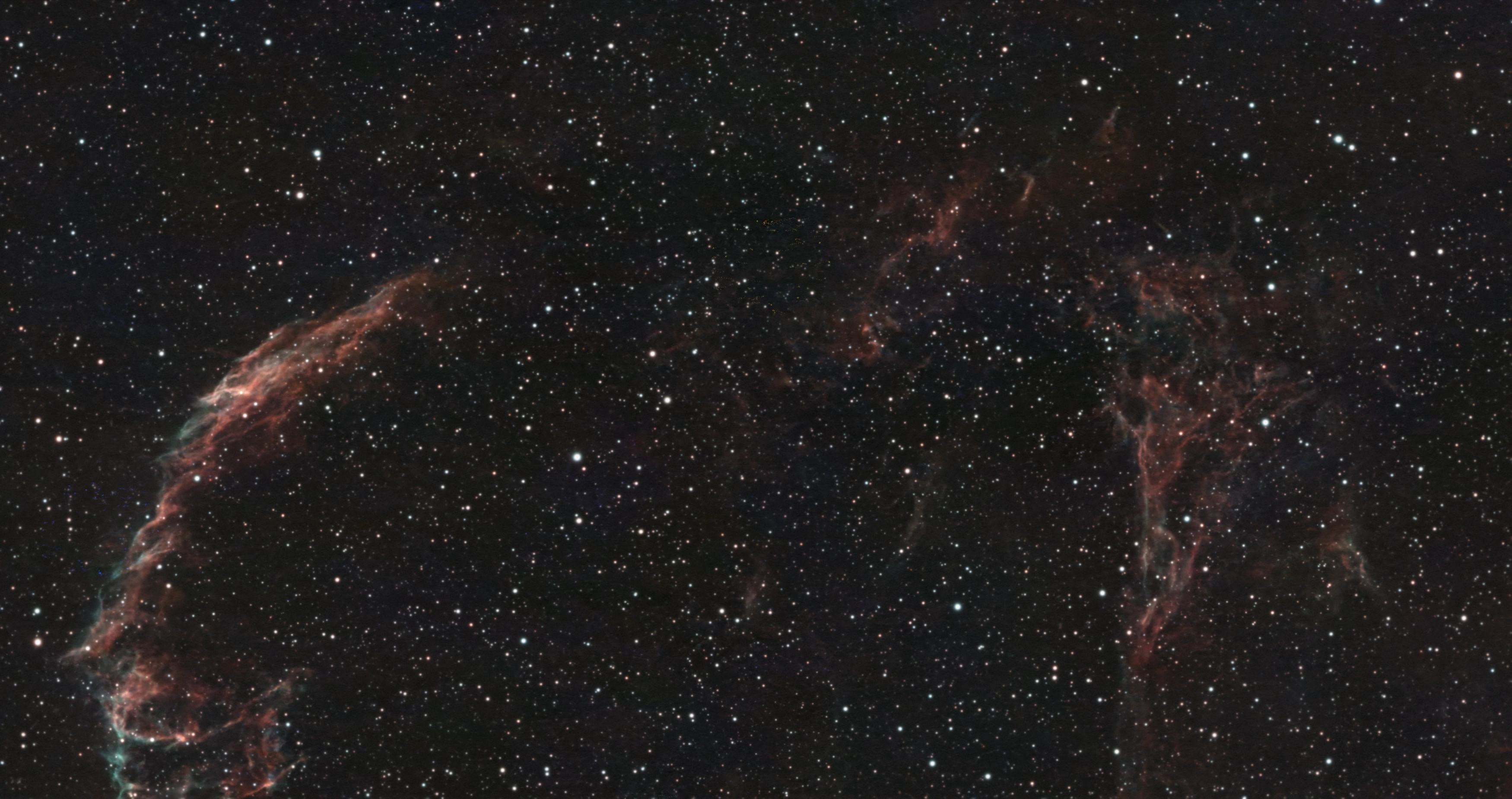 Red and blue-green filaments of the Eastern Veil Nebula in a dense star field